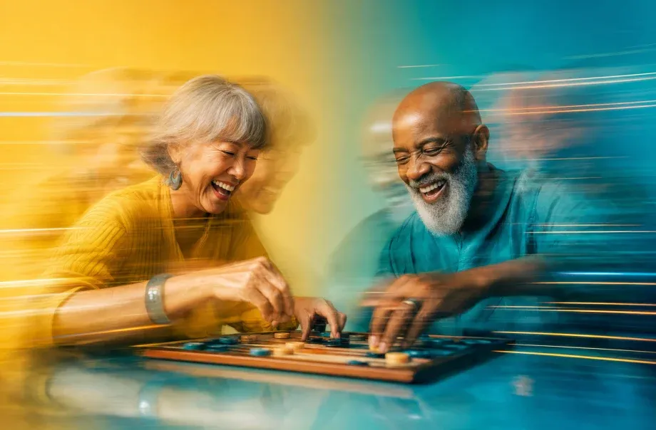 Two older residents laughing together over a board game, captured with long-exposure motion blur on a yellow and teal gradient.